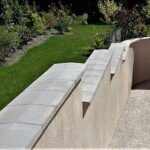 muro cinza com uma pingadeira de concreto no topo
