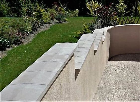 muro cinza com uma pingadeira de concreto no topo